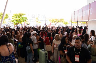 Multidão de profissionais com crachás de caravanista e malas na entrada do credenciamento da feira