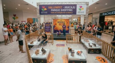 Imagem ilustrativa criada por IA de espaço do HallowPet no shopping, com filhotes de cães e gatos fantasiados em cercados e palco do Desfile Pet decorado com abóboras